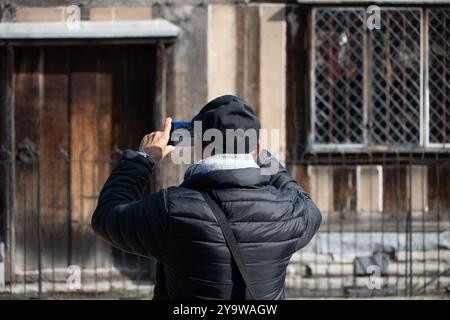 Male overseas tourist photographing Shakespeare`s birthplace with a mobile phone, Stratford-upon-Avon, Warwickshire, England, ,UK Stock Photo